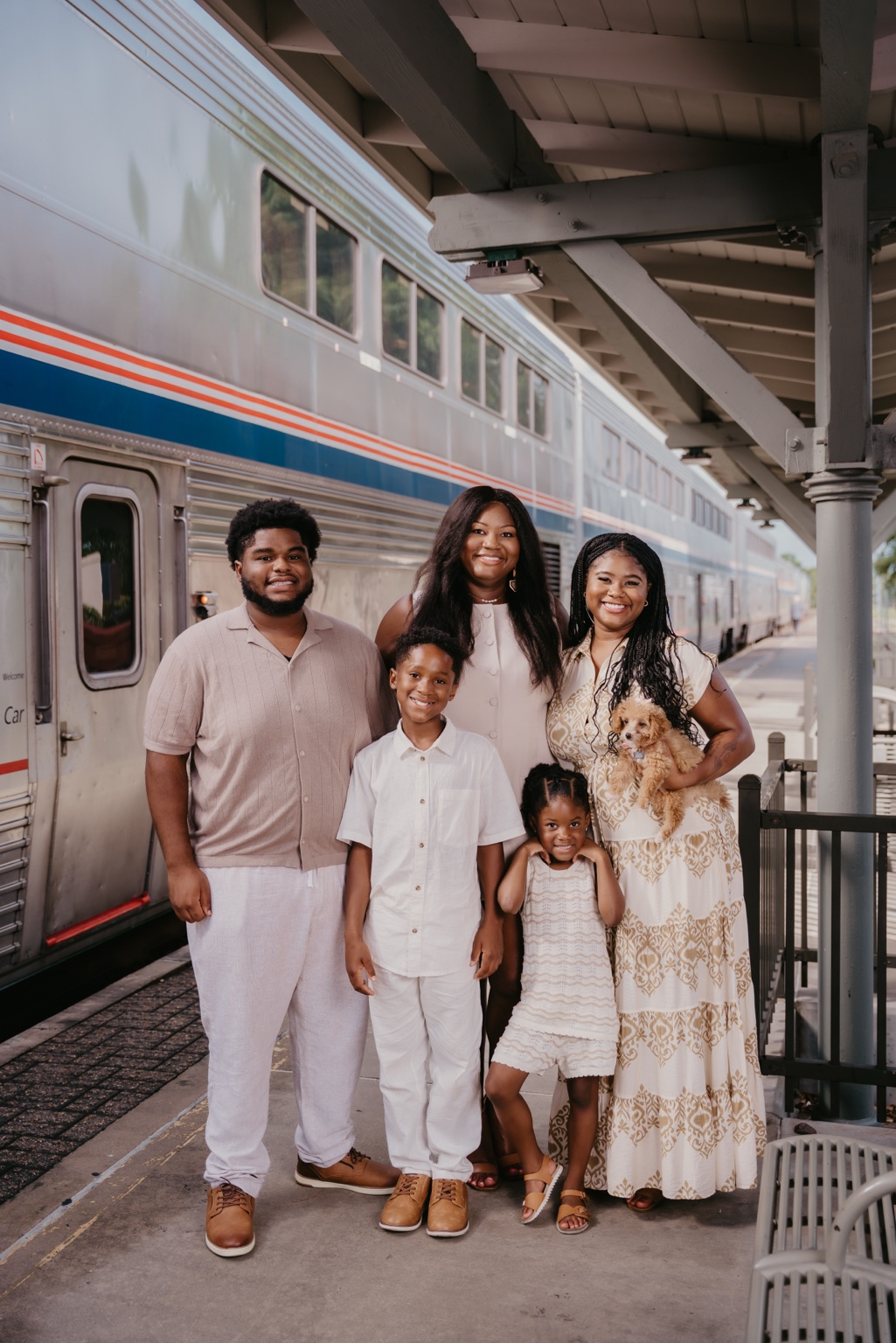 Jonetta Sam with her family beside a passenger train